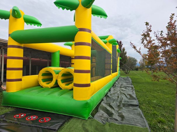 Structure gonflable colorée avec des arbres, prête à être utilisée dans un parc.